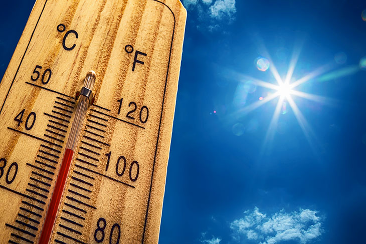 Image of thermometer displaying a high temperature with sun in the background